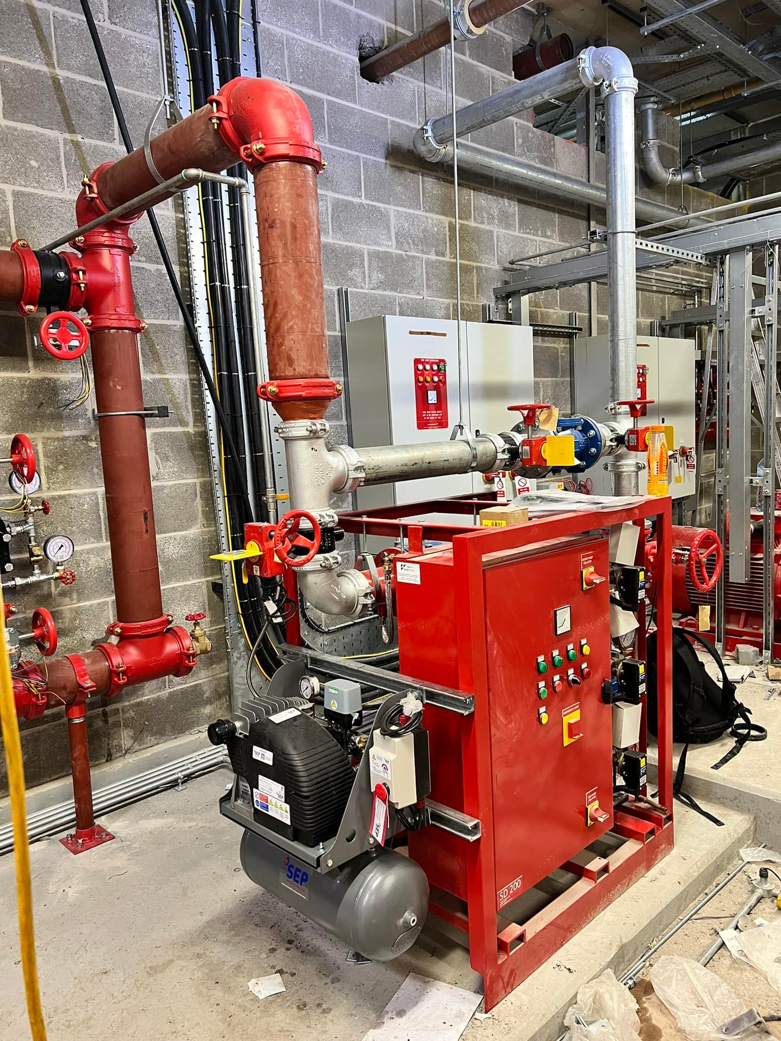 Fire sprinkler engineer inspecting valve set and control equipment